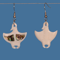 Pair of earrings with a manta ray design and paua center on a blue background