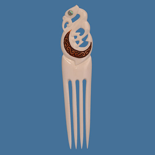 Decorative hair comb with intricate design on a blue background
