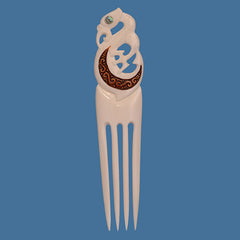 Decorative hair comb with intricate design on a blue background