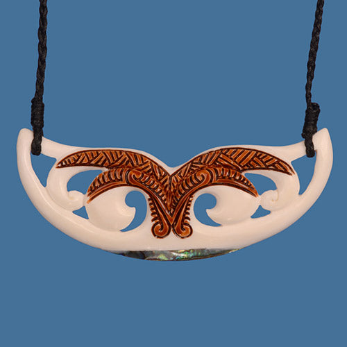 Decorative necklace with a white pendant and brown stained design on a blue background