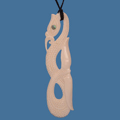 Carved bone pendant with intricate design on a blue background