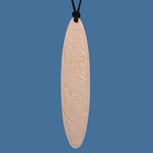 Carved bone pendant on a blue background