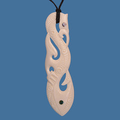 Carved bone pendant with intricate patterns on a blue background