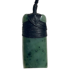 Green stone pendant with black cord on a white background