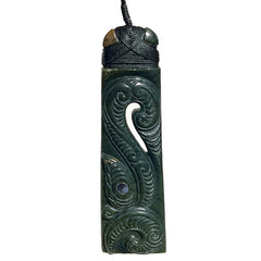 Green jade pendant with intricate carvings on a white background