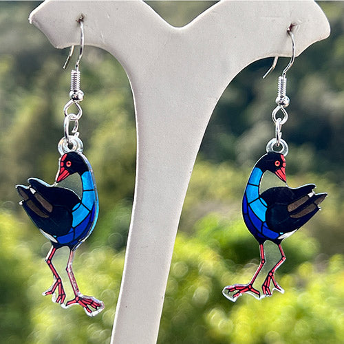 Pukeko on a white stand with a blurred green background