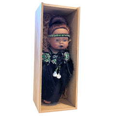 Doll with traditional attire and headdress on a white background
