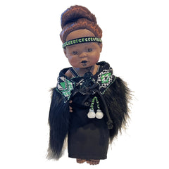 Doll with traditional attire and headdress on a white background