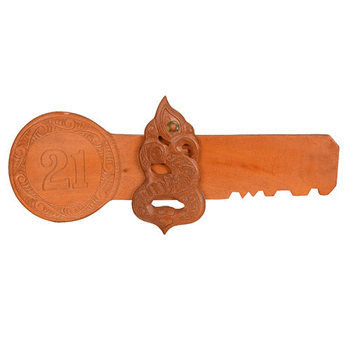 Wooden key with decorative carvings and number '21' on a white background