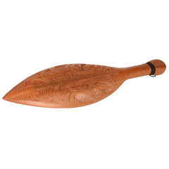 Wooden paddle with intricate carvings on a white background