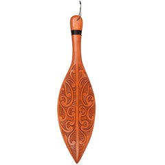 Wooden paddle with intricate carvings on a white background