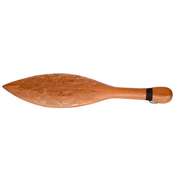 Wooden paddle with intricate carvings on a white background