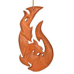 Wooden carvings of three dolphins on a white background