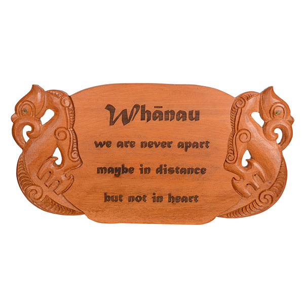 Wooden sign with carvings and engraved text on a white background