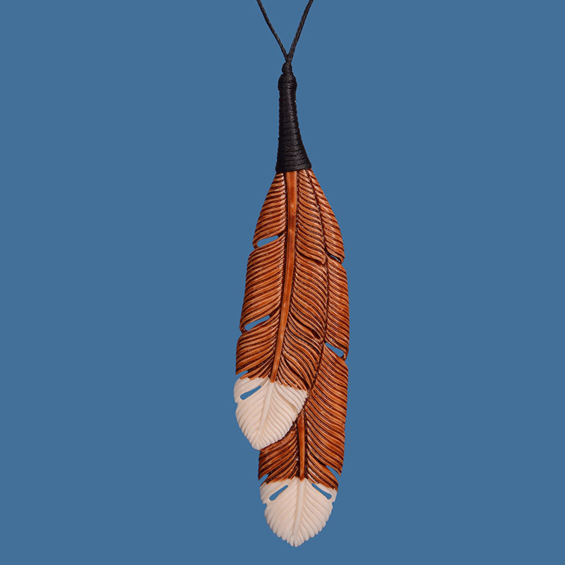 Carved bone brown Huia feather pendant. BP017